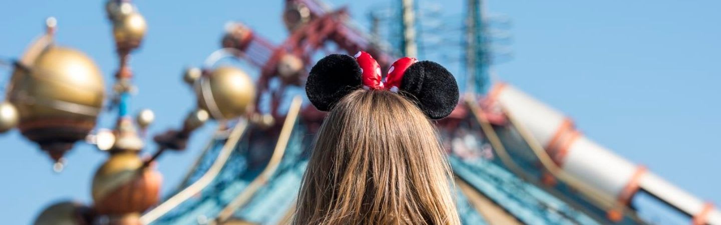 Ein Mädchen das im Disneyland Paris Mickey Mouse Ohren trägt
