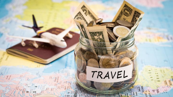 Passport, map, toy plane and vacation savings jar